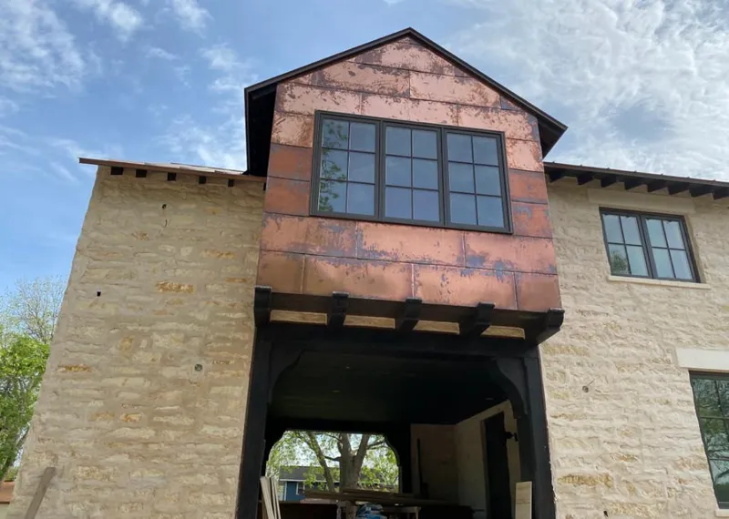 Copper metal panel facade on a stone building for Roof Repair in Willard