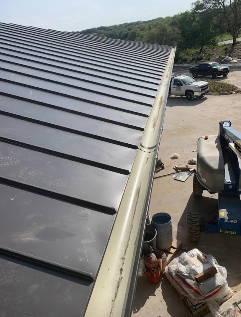 Standing seam panel and gutter detail on a metal roofing jobsite in Willard
